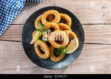 Nahaufnahme von knusprigen Calamari-Ringen, serviert auf Holztisch Stockfoto