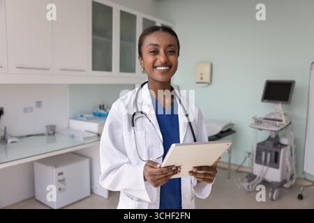 Porträt einer afrikanischen Ärztin, die mit Tablet für die Kamera posiert Stockfoto