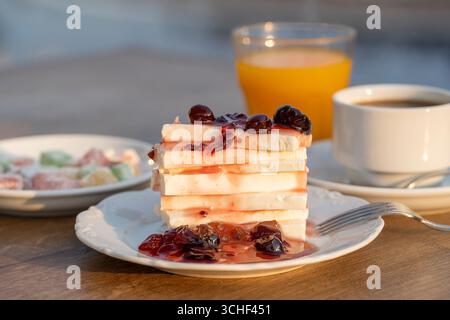 Quark mit roter Kirsche Marmelade, Orangensaft und eine Tasse Kaffee auf den Tisch. Frühstück Konzept. Nahaufnahme Stockfoto