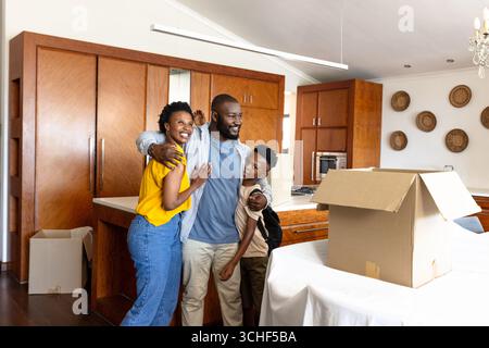 Familie auspackt Pappkartons in der Küche aus, lächelt und genießt neues Zuhause Stockfoto