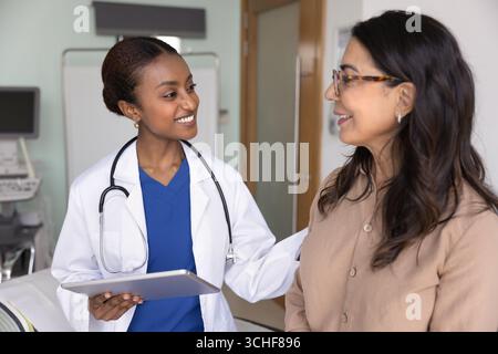 Arzt spricht mit weiblicher Patientin während ihres Krankenhausbesuchs Stockfoto