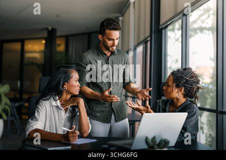 Kollegen streiten sich am Arbeitsplatz, Führungskräfte sind sich nicht einig über Papiere, fanden Vertragsfehler Stockfoto