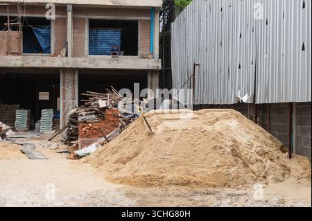 Gebäude im Bau mit gestapelten Materialien Stockfoto
