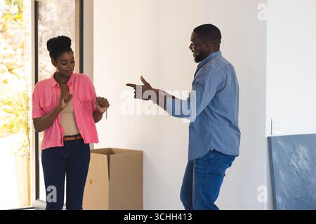 Paare tanzen fröhlich zu Hause, genießen Spaß und verspielte Momente zusammen Stockfoto