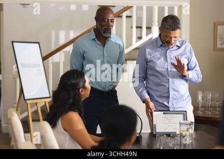 Er erhält den Preis für lebenslanges Erfolg, Mann feiert mit Freunden zu Hause, lächelt Stockfoto