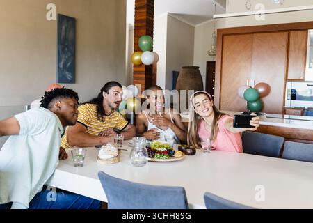 Verschiedene Freunde genießen ein Mittagessen, machen Selfie zu Hause, lächeln und haben Spaß Stockfoto