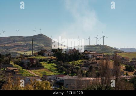 Windturbinen auf Hügeln hinter einer kleinen ländlichen Stadt Stockfoto