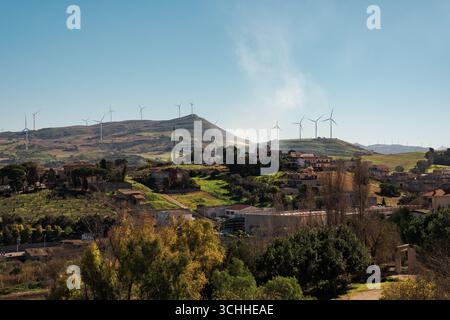 Windturbinen auf Hügeln hinter einer kleinen ländlichen Stadt Stockfoto