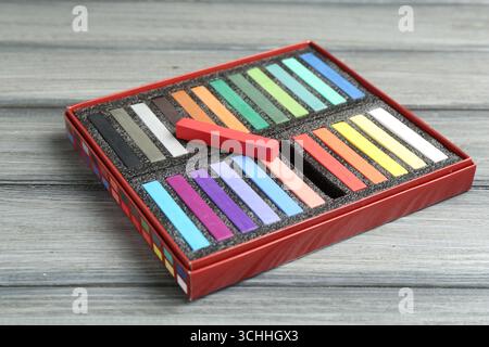 Bunte Kreidepastelltöne in Box auf Holztisch, Nahaufnahme Stockfoto