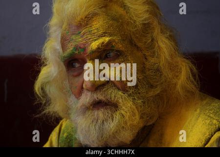 Ein indischer Einsiedler, auch Sadhu in Hindi genannt, sitzt nachdenklich während des Holi-Festivals in Vrindavan, Indien. Stockfoto