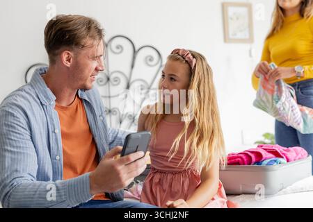 Vater und Tochter packen den Koffer zu Hause und bereiten sich auf den Familienausflug vor Stockfoto