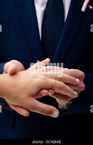 Ein Paar, das während der Hochzeitszeremonie Ringe austauscht, Hände hält und Liebe zeigt Stockfoto