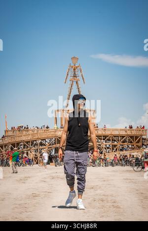 Man läuft in der Nähe der berühmten Holzstruktur beim Burning man Festival Stockfoto