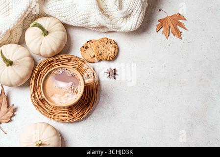 Herbstkonzept mit heißem Kaffeegetränk, weißen Kürbissen, Keksen und herbstlichen Ahornblättern auf weißem Hintergrund, Draufsicht, Kopierraum. Gemütliche Herbstkulisse Stockfoto