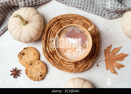 Herbstkürbis-Gewürzkaffee mit weißen Kürbissen, Keksen und herbstlichem Ahornblatt, Blick von oben. Stockfoto