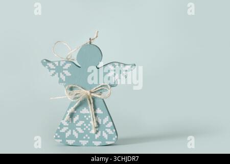 Weihnachten handgemachte Holzengel Handwerk aus natürlichen Materialien im scandi Stil stehen auf blauem Hintergrund. Weihnachtsdekoration bis zu festlichen Kulissen. Stockfoto