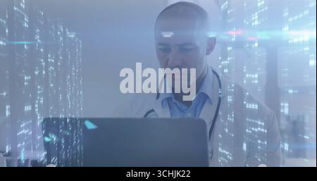 Arzt mit Laborkittel und Stethoskop, der in der Klinik am Laptop arbeitet, mit holographischer Überlagerung Stockfoto