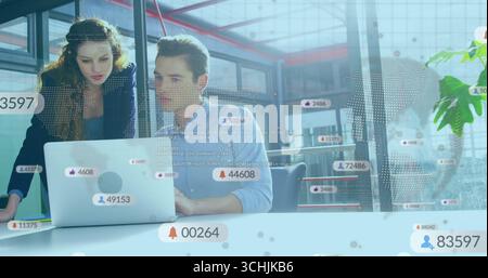Die Zusammenarbeit von Profis in Geschäftskleidung ist mit einem Laptop im Büro mit frei beweglichen Kartensymbolen ausgestattet Stockfoto