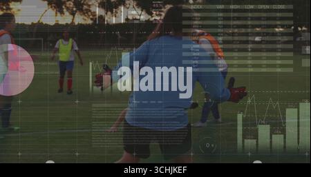 Torhüter taucht in der Abenddämmerung auf dem Rasenplatz mit roten Handschuhen, Neonlätzchen und digitalen HUD-Charts Stockfoto