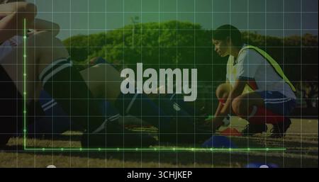 Fußballspieler mit gelben Lätzchen auf dem Rasenfeld, mit blauen Trainingskegeln, Kopierraum Stockfoto