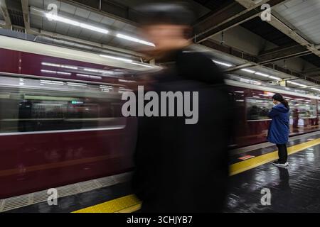 Ein Mann, der an der Osaka-Umeda Station in Osaka vorbeikommt Stockfoto