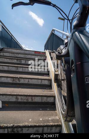 Treppen mit Fahrradkanal zum Schieben von Fahrrädern auf das Snelbinder Burg Bike und Fußgängerbrücke über den Waal bei Nijmegen wurden an die Exi angebaut Stockfoto