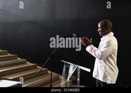 Geschäftsmann klatscht auf dem Podium während der Präsentation im modernen Konferenzsaal, Kopierraum Stockfoto