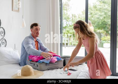 Vater und Tochter packen zusammen Koffer zu Hause und bereiten sich auf den Urlaub vor Stockfoto