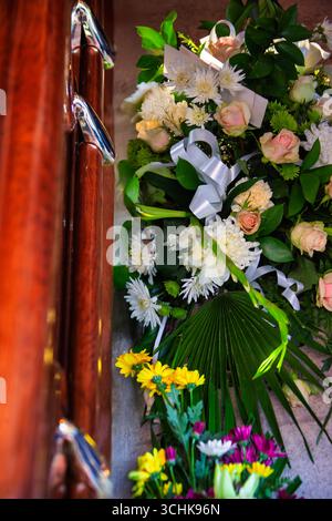 Sarg und Blumen, luxuriöser Holzschatulle und Blumenstrauß aus Blumen, Rosen und Nelken Stockfoto