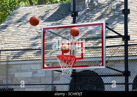 Mehrere Basketbälle schlagen während eines Aufwärmens vor dem Spiel auf das Rückbrett. Stockfoto