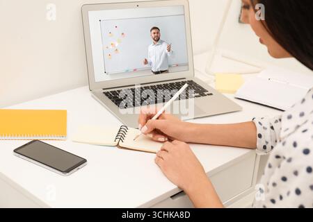 E-Learning-Konzept. Schüler, der Online-Videochat mit dem Lehrer über Laptop am Schreibtisch hat, Nahaufnahme Stockfoto