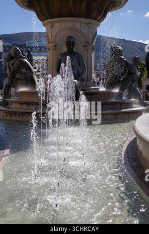Mutter-teresa-Brunnen, der die lebhaften Wasserstrahlen und die verschiedenen Bronzestatuen im Hintergrund einfängt. Das Bild hebt das komplizierte Design und hervor Stockfoto