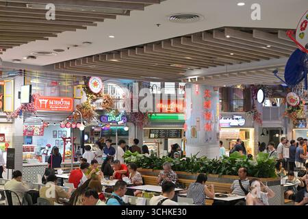 Ein geschäftiger Food Court zur Mittagszeit in einem eleganten Einkaufszentrum in Bangkok, mit einer großen Auswahl an thailändischen und internationalen Gerichten Stockfoto
