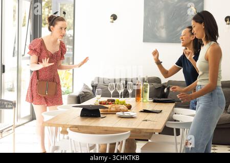 Drei junge Frauen, die sich zu Hause am Esstisch unterhalten Stockfoto