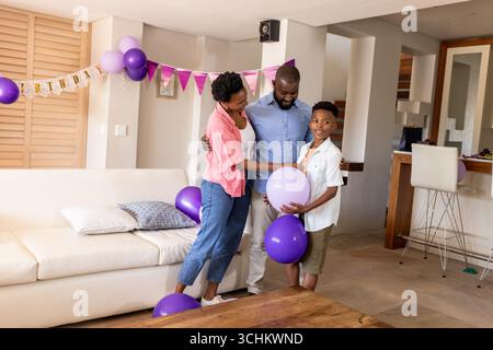 Glückliche Familie, die zu Hause Geburtstag mit Ballons und Dekorationen feiert Stockfoto