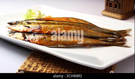 Gegrillter Pacific Saury Sanma auf weißer rechteckiger Platte Stockfoto