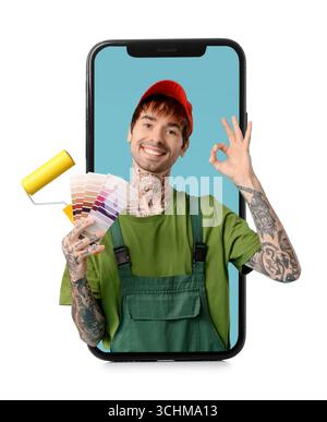 Männlicher Maler mit Farbpalettenmustern und Malerwalze auf dem Bildschirm des Mobiltelefons vor Hintergrund Stockfoto