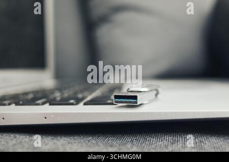 Laptop mit USB-Kabel. Der Laptop ist geöffnet und das Kabel ist eingesteckt Stockfoto
