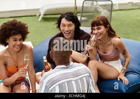 Freunde lachen und teilen sich Getränke und feiern bei einem lebhaften Treffen am Pool. Stockfoto