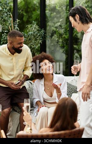 Freunde lachen an einem sonnigen Tag in einem belebten Café im Freien und machen sich unvergessliche Erinnerungen. Stockfoto