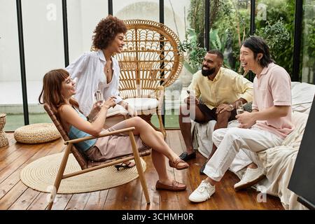 Eine Gruppe junger Freunde genießt eine gute Zeit in einem lebhaften Café im Freien und lacht. Stockfoto