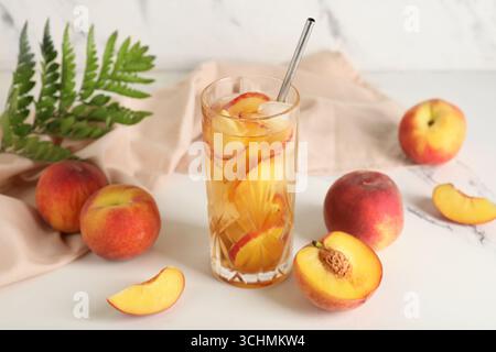 Serviette und Glas leckeren Pfirsicheistees auf Marmorhintergrund, Nahaufnahme Stockfoto