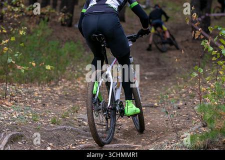 Radfahrer mit Rückansicht auf dem herbstlichen Waldweg beim Mountainbike-Wettbewerb Stockfoto