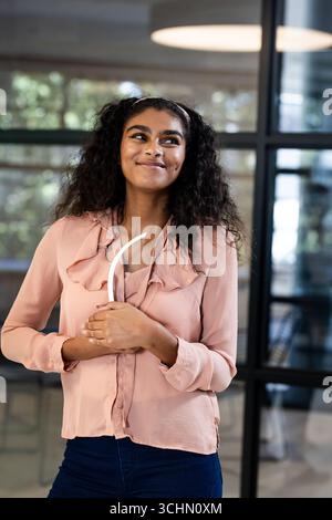 Lächelnd, Frau im modernen Büro, selbstbewusst und professionell Stockfoto