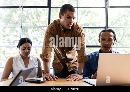Verschiedene Teams arbeiten an Projekten mit Laptops in moderner Büroumgebung zusammen Stockfoto