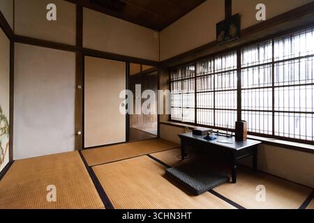 Das Innere eines ruhigen, traditionellen japanischen Zimmers mit Tatamimatten und einem niedrigen Schreibtisch am Fenster. Stockfoto
