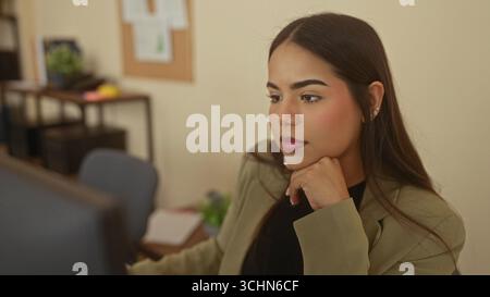 Eine Frau, die am Schreibtisch in einem Büro denkt und tief nachdenkt, verleiht der Arbeitsumgebung mit durchdachtem e einen Hauch von Professionalität und Nachdenklichkeit Stockfoto