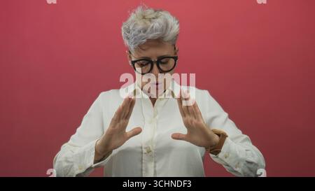 Brillenträger inhalieren mit offenen Handflächen im Studio mit fokussierter Frontalhaltung; meditative ruhige Fokusachtsamkeit. Stockfoto