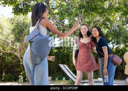 Lachend und posierend, genießen drei junge Frauen einen sonnigen Tag im Freien Stockfoto