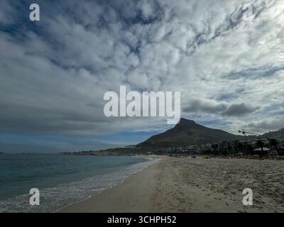 Eine Weitwinkelaufnahme eines Strandes in Kapstadt mit dem majestätischen Lion's Head Berg im Hintergrund. Das Foto zeigt den weiten Sandstreifen Stockfoto